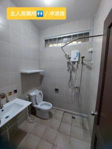 e bagno con doccia, servizi igienici e lavandino. di Sibu wawasan no.1 Homestay a Sibu