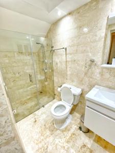 a bathroom with a shower and a toilet and a sink at Green Oasis Hotel in La Romana