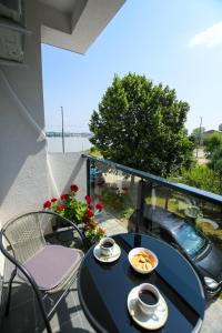 a table and chairs on a balcony with a view of the ocean at Apartman Plaža 2 in Kladovo