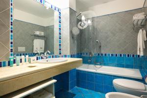 bagno blu con servizi igienici e lavandino di Hotel Hermitage a Portoferraio