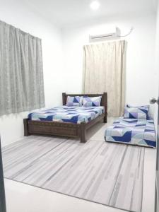 1 Schlafzimmer mit 2 Betten und einem Fenster in der Unterkunft Homestay Tok Kah in Kuala Terengganu
