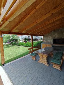 a patio with a table and chairs under a wooden roof at Barišić in Livno