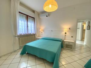 una camera con un letto blu e una finestra di Appartamento il Leccio a San Vincenzo