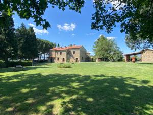 un gran patio con una casa al fondo en Agriturismo L'Antica Quercia, en Pomarance