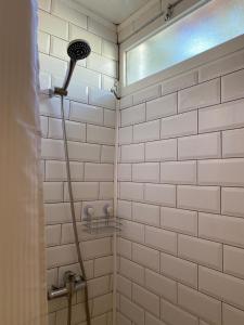 a white tiled shower with a shower head at The Tiles House in Faro
