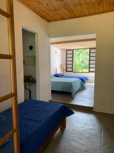a bedroom with two beds and a window at Arte de Minas in São Gonçalo do Sapucaí