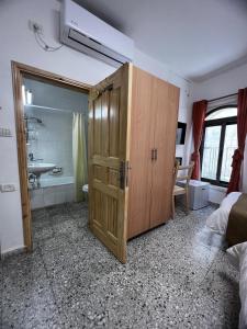 a bathroom with a large wooden cabinet in a room at William's Guest House in Jerusalem