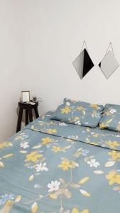 Una cama con una manta azul con flores. en Casa IWANA, en Guayaquil
