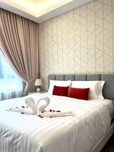 ein weißes Bett mit roten und weißen Kissen darauf in der Unterkunft Hotspring 2Room Oasis Suit @ Sunway Onsen with Theme Park View(5pax) in Tambun