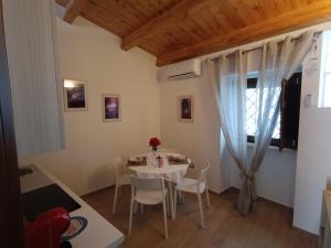 una piccola sala da pranzo con tavolo e sedie bianchi di OH CHE BEL CASTELLO a Ortona Altre 10 foto