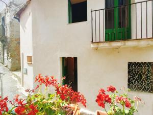 ein Gebäude mit roten Blumen und einem Balkon in der Unterkunft Albergo Diffuso Borgo Santa Caterina "Quartire Hebraic" in Castiglione di Sicilia