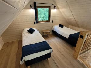 2 camas en una habitación pequeña con ventana en Kemping nad stawem, en Harsz