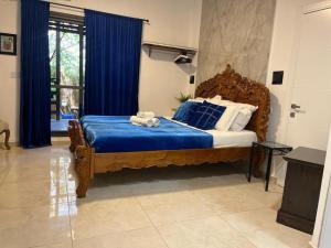 Schlafzimmer mit einem großen Holzbett mit blauer Bettwäsche in der Unterkunft Ahuzat Shaul Seaside in H̱adera