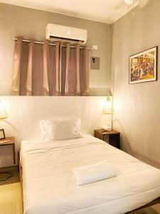 1 Schlafzimmer mit einem weißen Bett und Klimaanlage in der Unterkunft Green Oasis Hotel in La Romana