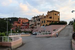 a parking lot with a bunch of buildings in the background at Appartement Dans un Terrain de Golf, 5 min de la mer en Voiture, Parking Gratuit in Cogoleto