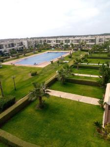 uma vista para um parque com uma piscina em Magnifique villa avec piscine privée dans une résidence sécurisée em Sidi Rahal