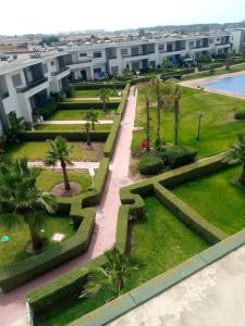 uma vista aérea de um parque com palmeiras e um edifício em Magnifique villa avec piscine privée dans une résidence sécurisée em Sidi Rahal