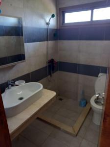 uma casa de banho com um lavatório, um chuveiro e um WC. em Magnifique villa avec piscine privée dans une résidence sécurisée em Sidi Rahal