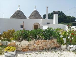 a white house with plants in front of it at Trullo in piena valle d'itria del 1800 in Cisternino