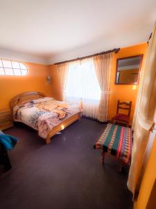 - une chambre avec un lit, une chaise et une fenêtre dans l'établissement Cabañas Utama, à Copacabana