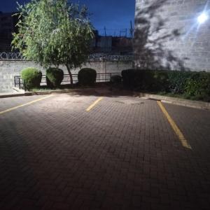 un parking vide la nuit avec un bâtiment dans l'établissement Cosy, serene and affordable 2bdr apartment off Waiyaki way, à Nairobi