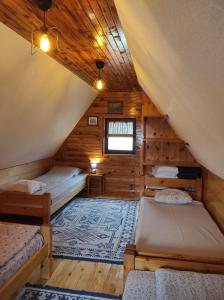 a attic room with two beds and a rug at Orange House in nature in Žabljak