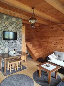 a living room with a table and a stone wall at Orange House in nature in Žabljak