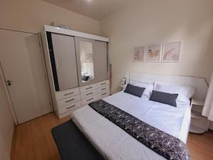 1 dormitorio con 1 cama grande y espejo grande en Apto com VAGA entre Botafogo e Copacabana, en Río de Janeiro