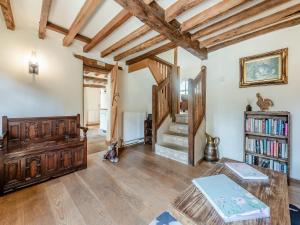 salon z drewnianymi podłogami i drewnianymi belkami stropowymi w obiekcie Ellen Cottage w mieście Burford
