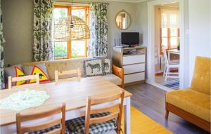 uma sala de estar com uma mesa e um sofá em Stunning Home In Gunnarskog With Kitchen em Gunnarskog
