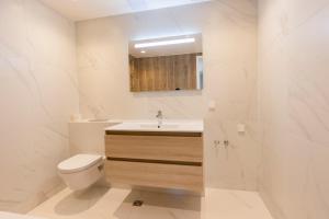 a white bathroom with a toilet and a sink at Beautiful apartment next to the Kalev Stadium in Tallinn