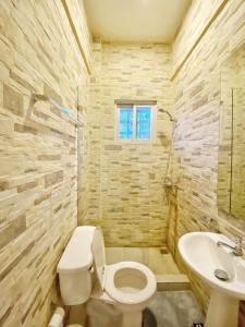 a bathroom with a toilet and a sink at Green Oasis Hotel in La Romana