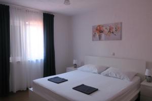 a bedroom with a white bed with two towels on it at Mesić Apartment in Senj