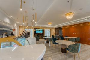 a restaurant with tables and chairs in a room at Jawhrat Al Sharq Serviced Apartments in Al Khobar