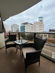 balcón con 2 sillas, mesa y ventana en Inkari Apart Hotel, en Lima