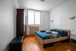 1 dormitorio con cama y banco. en Le coquet chez Maguy Maison de ville avec jardin en Besanzón