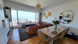 a living room with a table and a couch at SeaCityView Oostende in Ostend