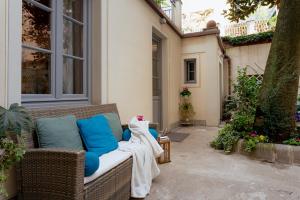 un sofá de mimbre sentado fuera de una casa en Il Cortile di Elisa & our flats, en Lucca