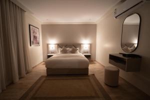 a bedroom with a large white bed and a mirror at Orient Jewel in Al Khobar