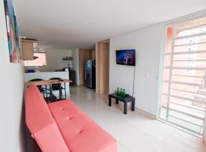 sala de estar con sofá rojo y cocina en Hostal Casa Doña Eva -Rionegro Antioquia en Rionegro