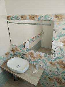 La salle de bains est pourvue d'un lavabo et d'un miroir. dans l'établissement Mare D'amare, à Porto Cesareo