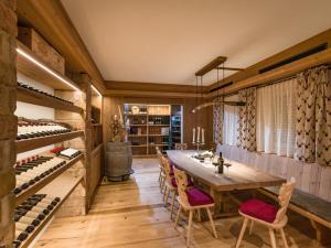 a dining room with a table and a wine cellar at Hotel & Alpin Lodge Der Wastlhof in Niederau