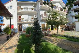 a white building with a christmas tree in front of it at Vila Flory & Crystiana in Costinesti