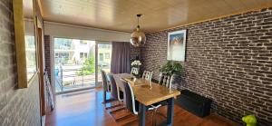 a dining room with a brick wall and a table and chairs at @Zakibelle in Bredene