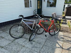 dos bicicletas estacionadas frente a una casa en Tiny house naast Kniphorstbosch, en Anloo