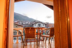 Un balcón con sillas y una mesa con vistas. en Guest House Angelkovi en Sapareva Banya