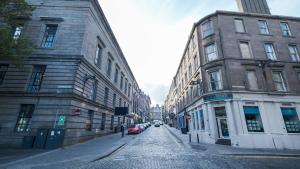 a cobblestone street in a city with tall buildings at Stylish 2 Bed Dundee City Centre Flat in Dundee