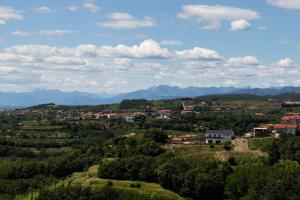 una città su una collina con montagne sullo sfondo di Vinoteka Brda a Šmartno (San Martino)