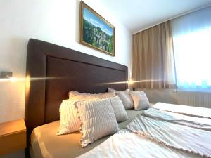 1 dormitorio con 1 cama grande con almohadas blancas en Hotel Garni Neue Schänke en Königstein an der Elbe