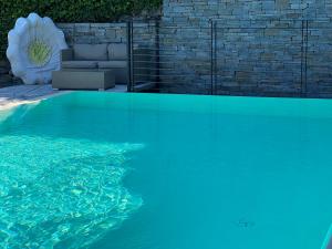 een zwembad met blauw water in een tuin bij Villa Nogara in Menaggio